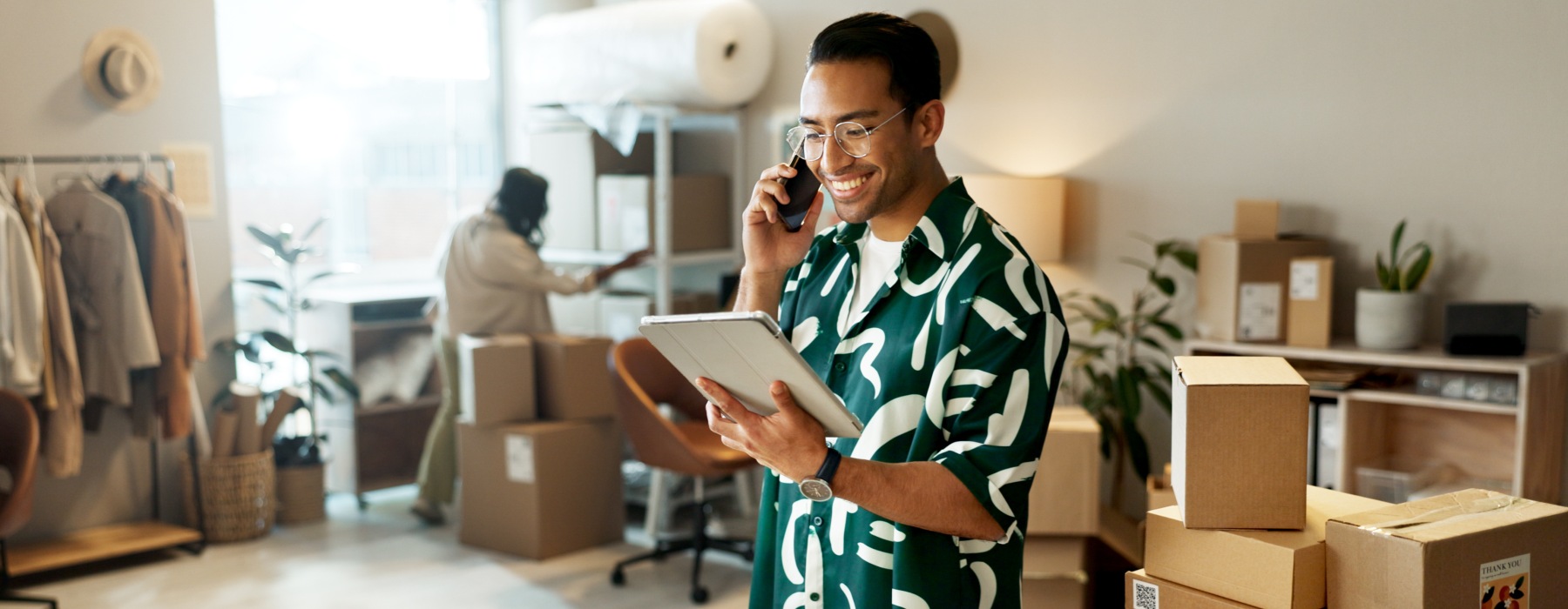 A smiling person looking at a tablet.