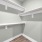 well lit walk-in closet with shelving